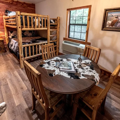 A luxury suite with large windows overlooking a giraffe barn, capturing the unique wildlife experience at Oak Meadow Ranh RV in Valley View, TX.