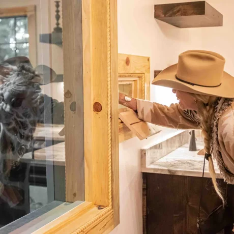 A person or couple feeding a giraffe from their accommodation, capturing the unique safari experience available onsite at Oak Meadow Ranch RV in Valley View, TX.