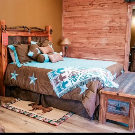 A cozy, wooden cabin nestled in a scenic setting with the sun setting behind it, emphasizing the rustic charm and peaceful atmosphere at Oak Meadow Ranch RV in Valley View, TX.