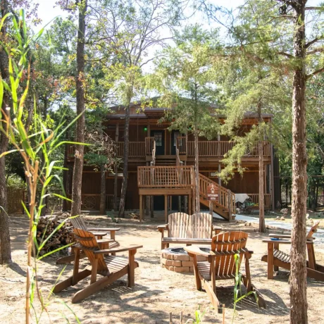 A luxury suite with large windows overlooking a giraffe barn, capturing the unique wildlife experience at Oak Meadow Ranh RV in Valley View, TX.