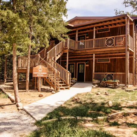 A luxury suite with large windows overlooking a giraffe barn, capturing the unique wildlife experience at Oak Meadow Ranh RV in Valley View, TX.