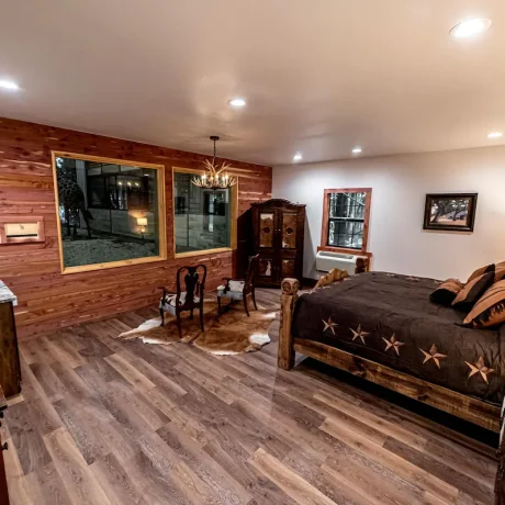 A luxury suite with large windows overlooking a giraffe barn, capturing the unique wildlife experience at Oak Meadow Ranh RV in Valley View, TX.